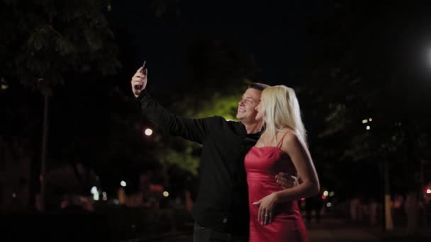 Amoureux romantiques heureux prennent un selfie dans la soirée . — Video