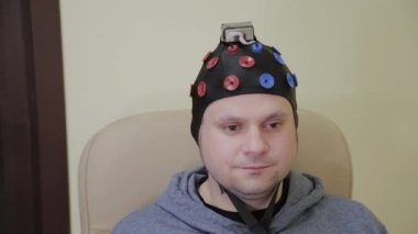 Doktor bir adama insan beyninin çalışması için bir kulaklık takıyor..