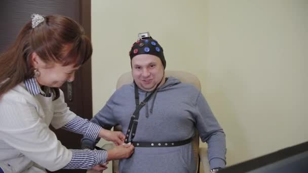 의사는 인간의 뇌의 연구를위한 헤드셋을 남자에 넣어. — 비디오