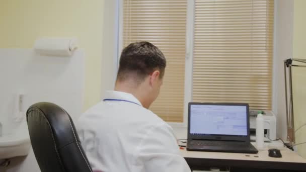 Чоловік лікар запрошує пацієнта вступити в кабінет . — стокове відео