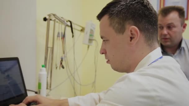 Erkek hasta doktora sağlık şikayetlerini anlatıyor. — Stok video