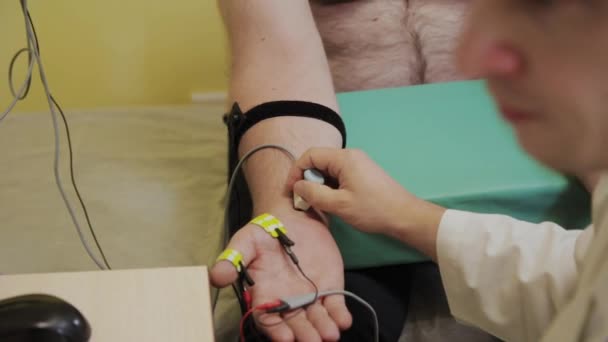 Чоловік-лікар оглядає пацієнта з медичним пристроєм . — стокове відео