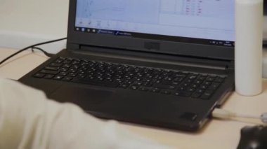 Doktor klinikte bilgisayarbaşında çalışıyor..