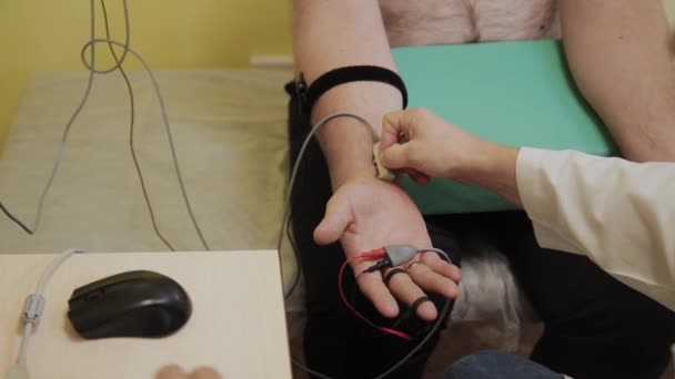 El médico masculino examina a un paciente con un dispositivo médico . — Vídeo de stock