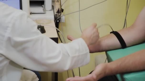 Mannelijke arts onderzoekt een patiënt met een medisch hulpmiddel. — Stockvideo