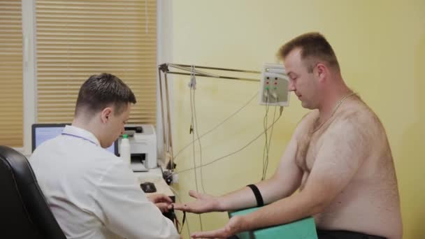 Ο άνδρας γιατρός εξετάζει έναν ασθενή με ιατρική συσκευή. — Αρχείο Βίντεο