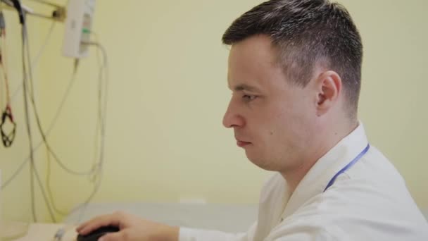 Arzt arbeitet in der Klinik am Computer. — Stockvideo