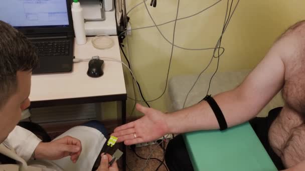 男性医師が医療機器を持つ患者を診察する. — ストック動画