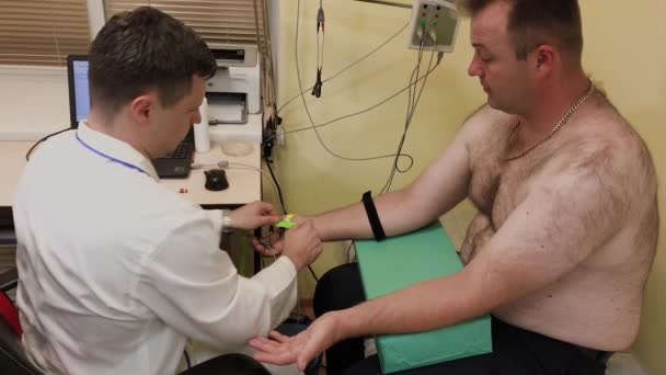 Homme médecin examine un patient avec un dispositif médical . — Video