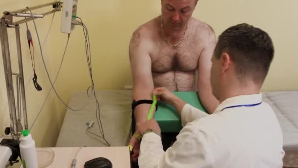 Врач-мужчина осматривает пациента с помощью медицинского устройства . — стоковое видео