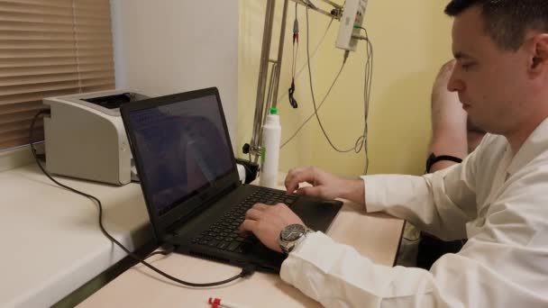 Mužský lékař zkoumá pacienta se zdravotnickým prostředkem. — Stock video