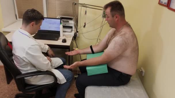 Mężczyzna lekarz bada pacjenta z urządzeniem medycznym. — Wideo stockowe