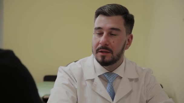 Male doctor takes a patient in his office. — Stock Video