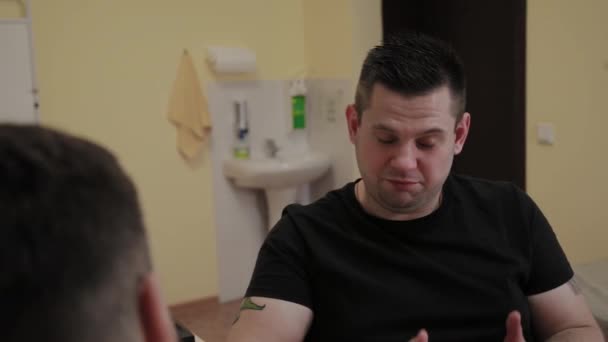 Мужчина пациент рассказывает врачу о своих проблемах со здоровьем на ресепшене . — стоковое видео