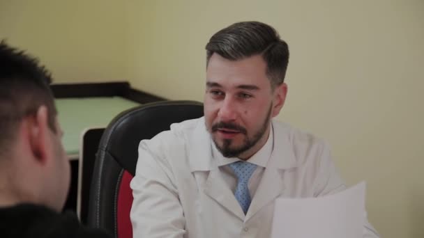 Male doctor takes a patient in his office. — Stock Video