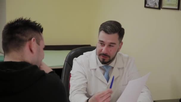 Male doctor takes a patient in his office. — Stock Video