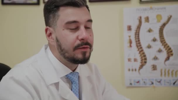 Мужчина-врач принимает пациента в своем кабинете . — стоковое видео