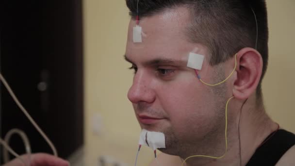 对诊所的病人，一位男护士在身体上放置一个设备来研究身体参数. — 图库视频影像