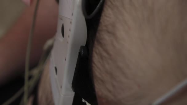 Einem Patienten in einer Klinik legt ein Krankenpfleger ein Gerät an seinen Körper, um Körperparameter zu untersuchen. — Stockvideo