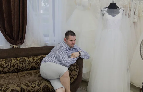 Jovem senta-se em um sofá em um salão de casamento . — Fotografia de Stock