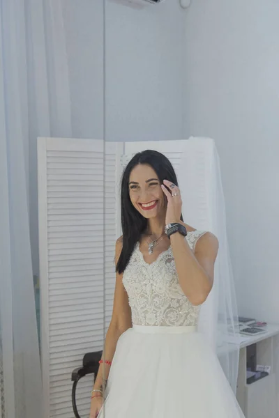 Hermosa chica se prueba un vestido de novia en un salón de novias . —  Fotos de Stock