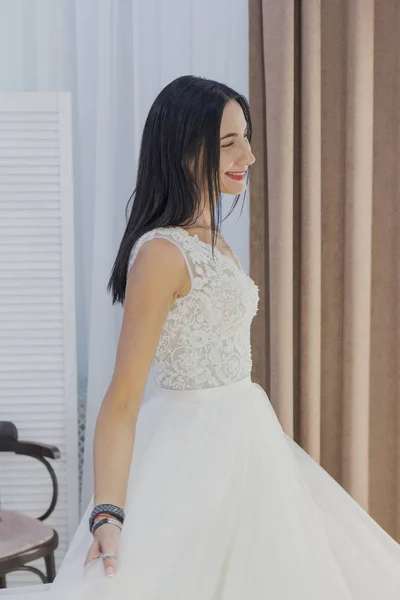 美丽的女孩尝试在新娘沙龙的婚纱. — 图库照片