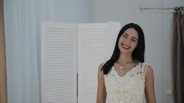 Schöne Mädchen misst ein Hochzeitskleid in einem Brautsalon. — Stockvideo