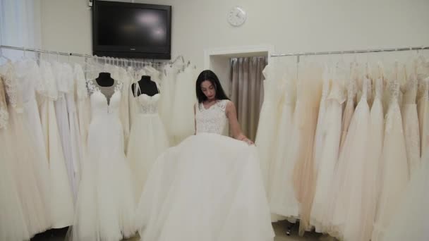 Belle fille mesure une robe de mariée dans un salon de mariée . — Video