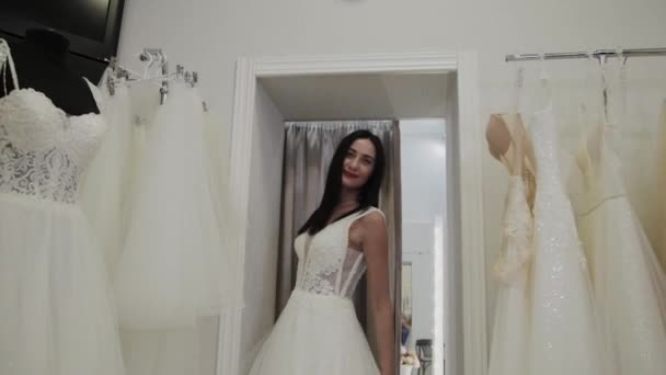Красива дівчина вимірює весільну сукню в весільному салоні . — стокове відео