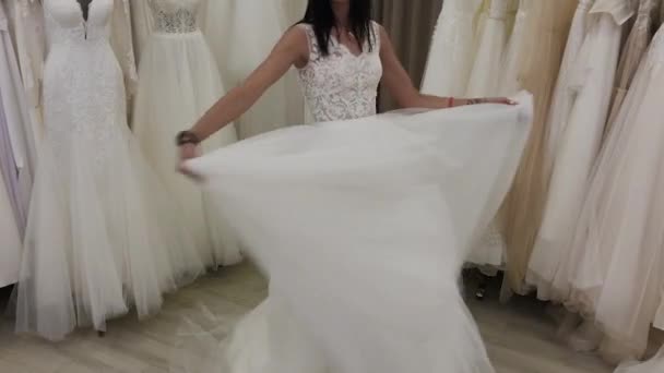 美丽的女孩测量婚纱在新娘沙龙. — 图库视频影像