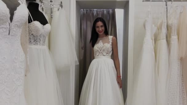 Krásná dívka měří svatební šaty v svatebních kadeřnictví. — Stock video