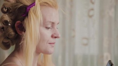 Profesyonel kuaför kadın elinde bir telefon ile oturan bir modelin saç tarzı fotoğraf yapıyor.