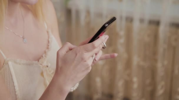 Mulher cabeleireira profissional fazendo uma foto em estilo de cabelo de um modelo que está sentado com um telefone em suas mãos . — Vídeo de Stock