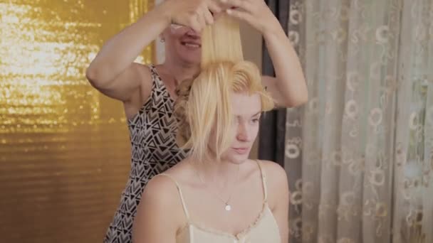 Professionele kapper vrouw doet kapsel foto van model. — Stockvideo