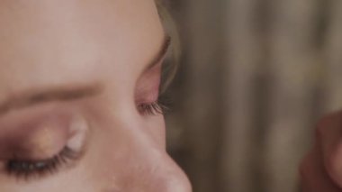 Profesyonel makyaj sanatçısı kadına model makyaj fotoğrafı uygular.