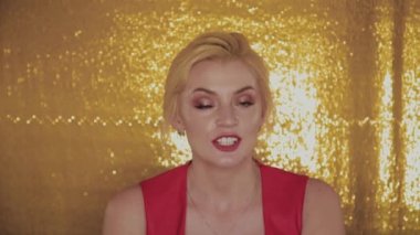 Güzel fotoğraf modeli bir fotoğraf stüdyosunda altın bir arka plan üzerinde poz.