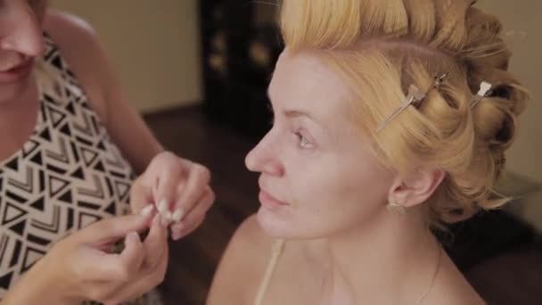 Professionell make-up artist applicerar make-up Foto av modell till kvinna. — Stockvideo