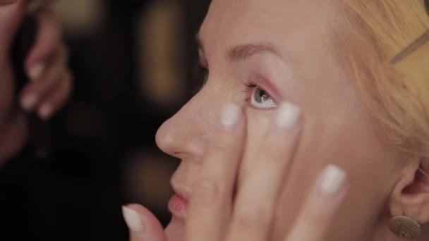 Professionelle Visagistin trägt Make-up-Foto des Models auf Frau auf. — Stockvideo