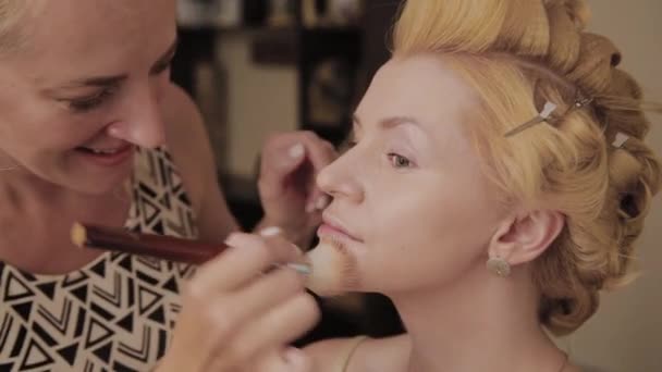 Επαγγελματική Μακιγιά καλλιτέχνη εφαρμόζει τη φωτογραφία του μοντέλου σε γυναίκα. — Αρχείο Βίντεο