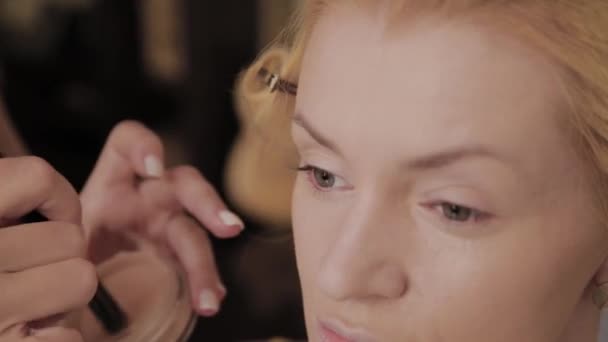 Maquilleuse professionnelle applique la photo de maquillage du modèle à la femme . — Video