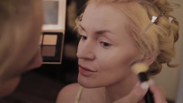 Professionelle Visagistin trägt Make-up-Foto des Models auf Frau auf. — Stockvideo