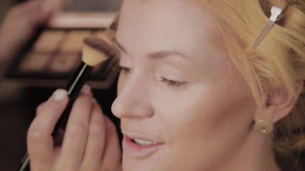 Professionell make-up artist applicerar make-up Foto av modell till kvinna. — Stockvideo