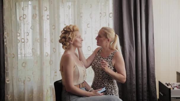 Profesyonel makyaj sanatçısı kadına model makyaj fotoğrafı uygular. — Stok video