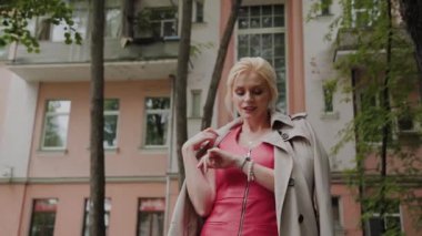 Kırmızı elbiseli fotoğraf modeli eski avluda yürüyor.