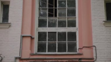Eski avluda büyük pencereleri olan eski bina.