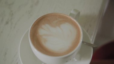 Bir kahve dükkanında bir masada lezzetli kapuçino Fincan.