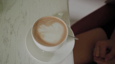 Genç kadın bir fincan kahve alır.