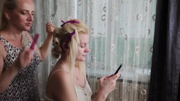 Professional hairdresser woman doing hairstyle photo of model. — Stock Video