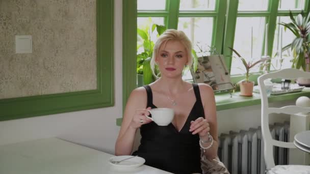 Красивая молодая деловая женщина пьет кофе в кафе . — стоковое видео