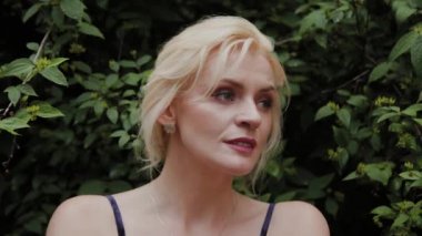 Güzel kadın fotoğraf modeli yaz aylarında yeşil çalılar duruyor.